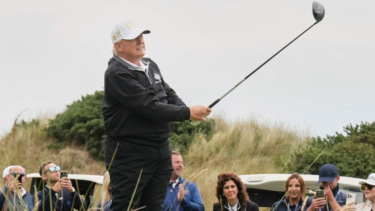 President Donald Trump tees off during the opening ceremony for the Trump International Golf Links golf course.