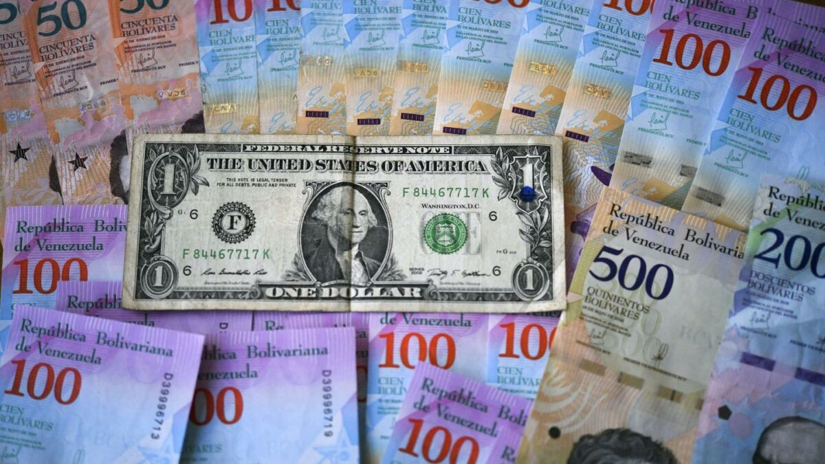 Venezuelan bolivar banknotes and a U.S. one-dollar bill.