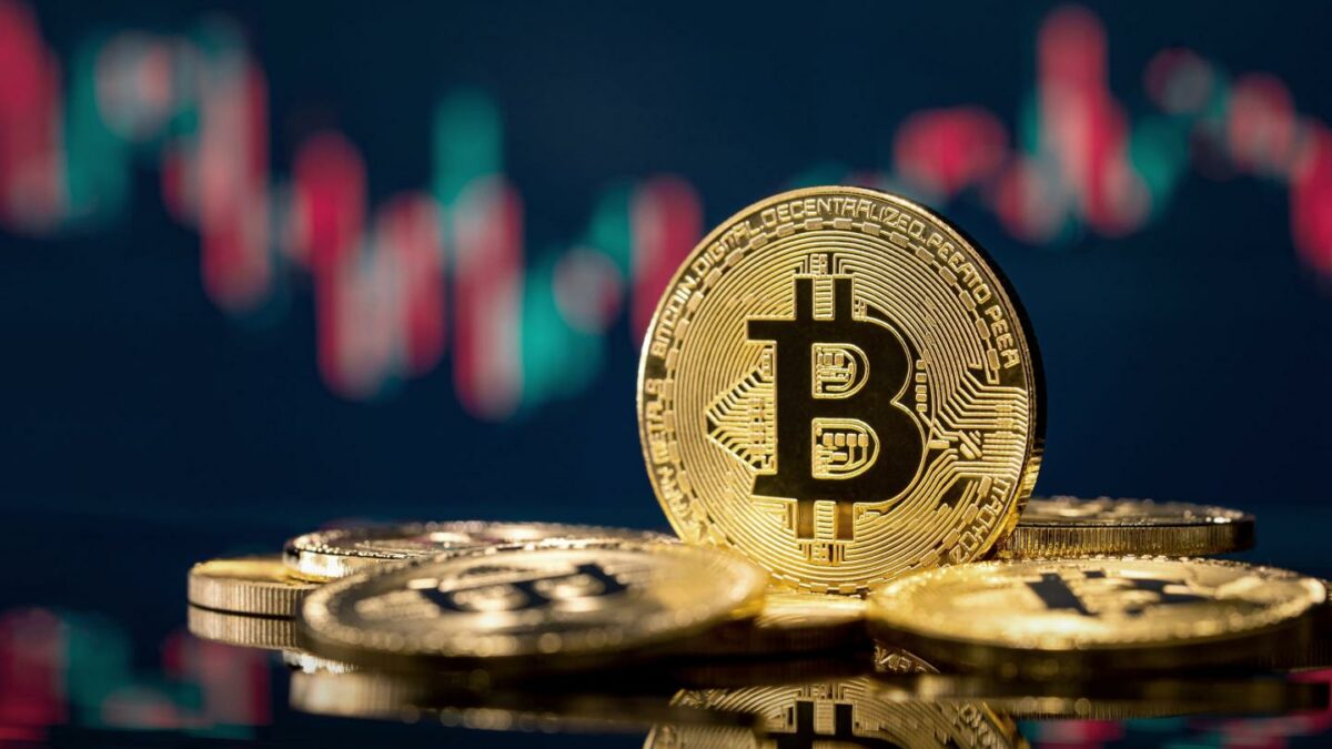 A picture of Bitcoin with a backdrop of a trading chart.