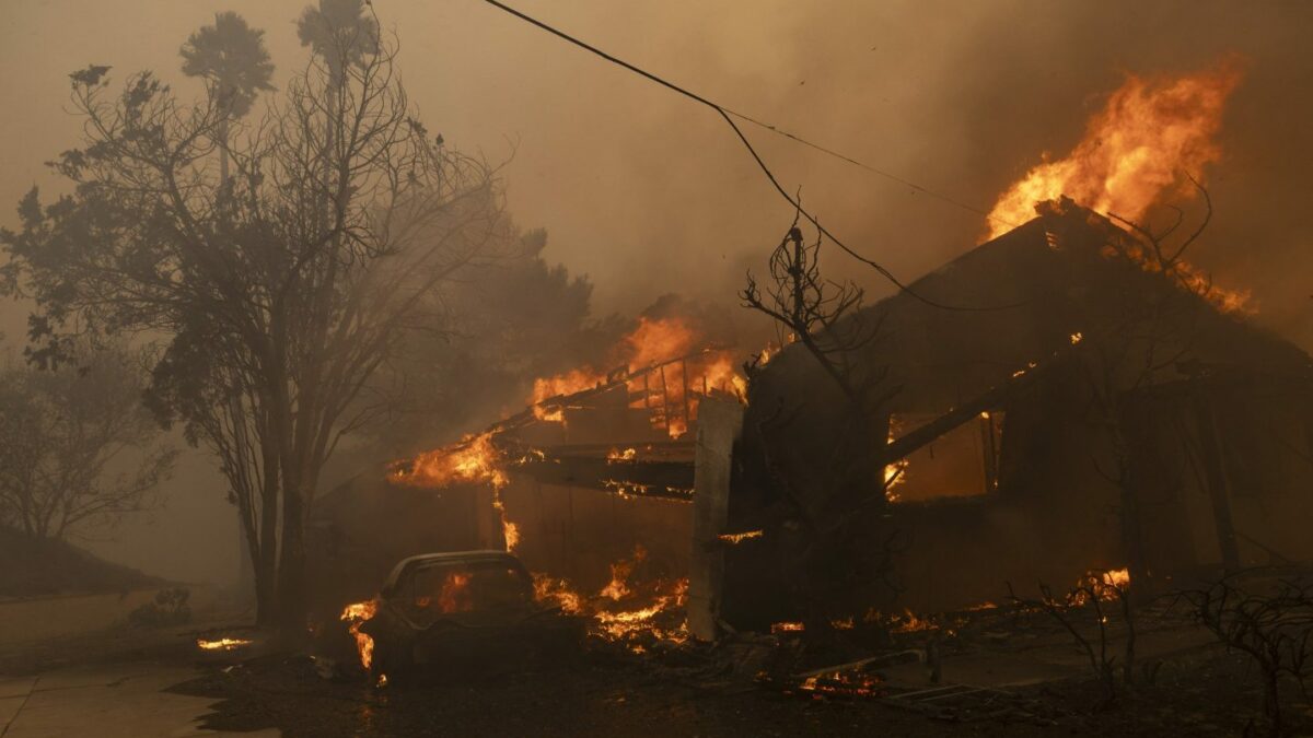 A house is engulfed in the flames of the Mountain Fire as the wildfire scorches acres in Camarillo Heights, Camarillo, California.