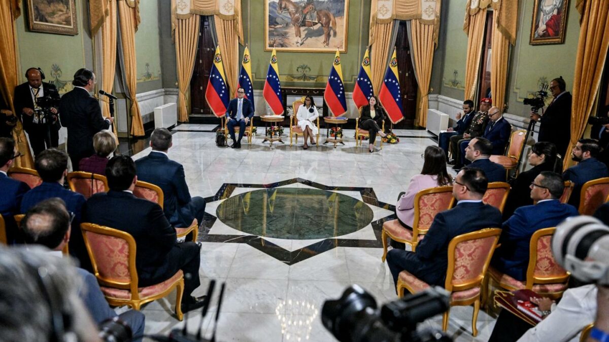 Venezuela interim President Delcy Rodriguez (C) looks on next to Sectoral Vice President for Economy and Finance Calixto Ortega (L) and Minister of Petroleum and Hydrocarbons Paula Henao during a press conference after a signing of an agreement ceremony between Chevron Venezuela and the national government at the Miraflores Palace in Caracas on April 13, 2026.