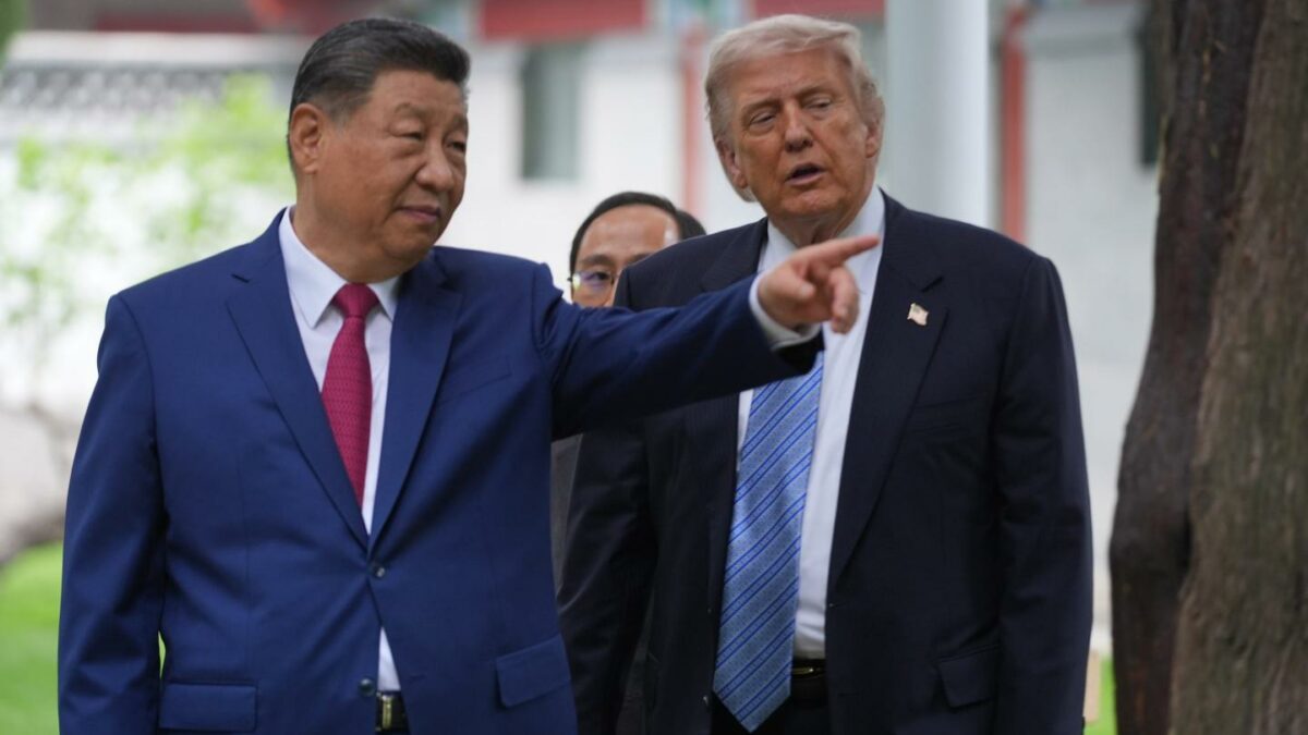 Xi Jinping, standing next to Donald Trump, points to his left.