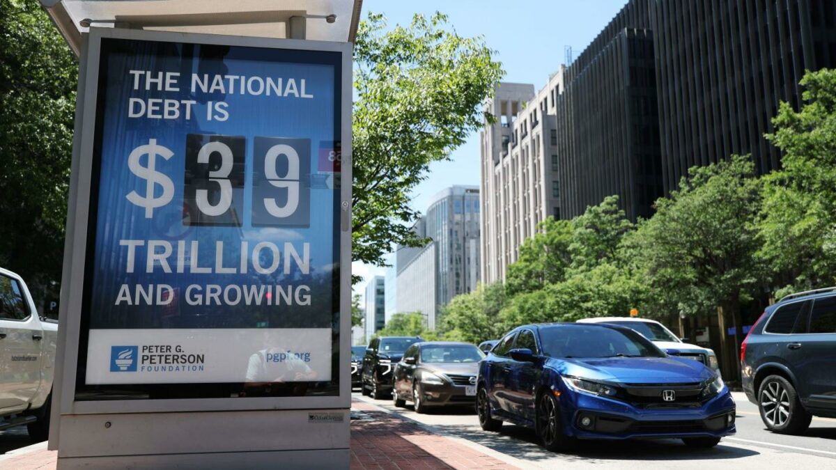 A sign on a bus stop displays the national debt on June 12, 2026, in Washington, D.C.