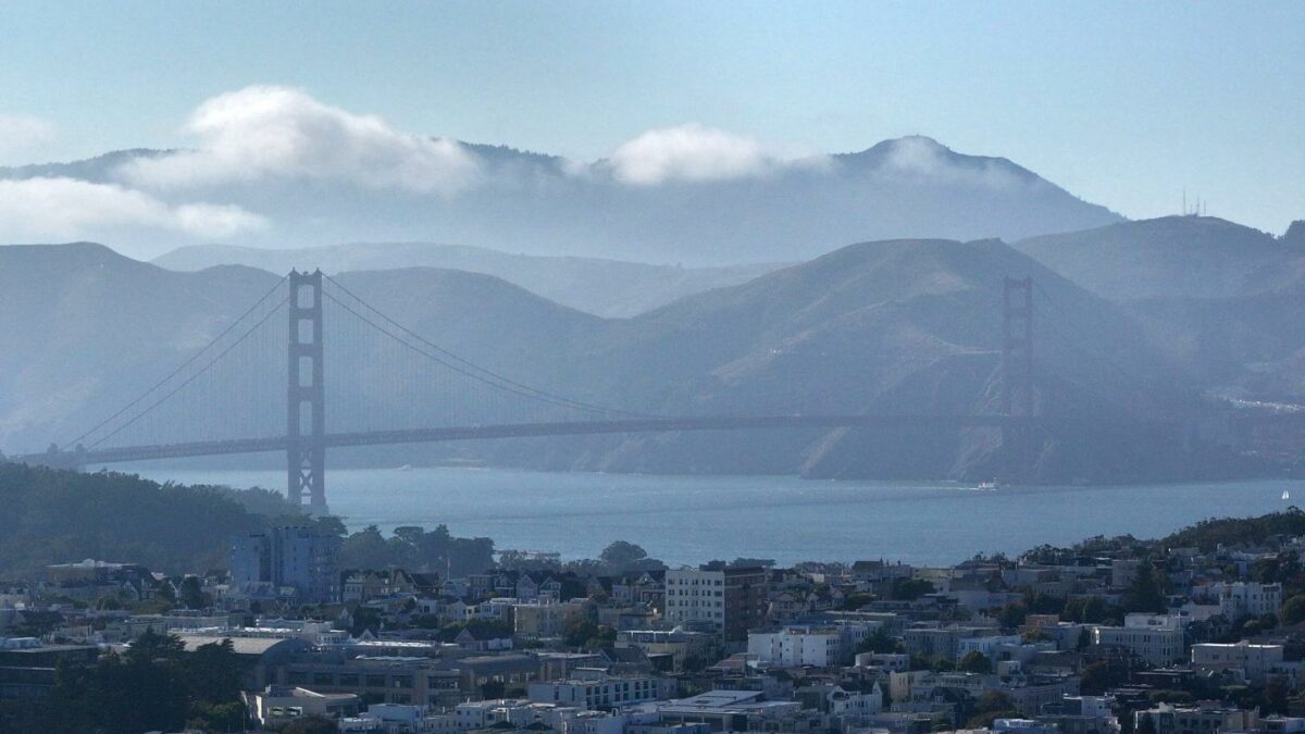A view of Golden Gate Bridge and houses during warm weather in San Francisco, California, United States.