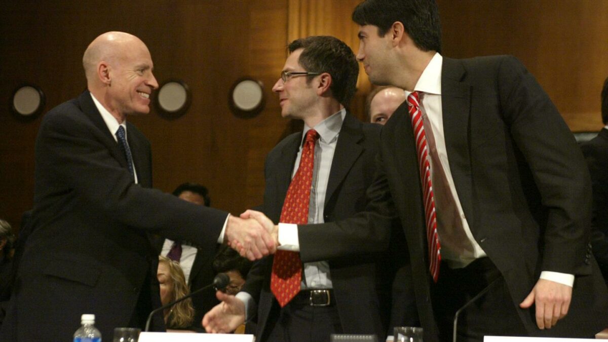 Edward P. Lazear, left, congratulates Randall S. Kroszner, center and Kevin M. Warsh, right, at the conclusion of their confirmation hearing held by the Senate Banking, Housing and Urban Affairs Committee in Washington, DC, February 14, 2006.