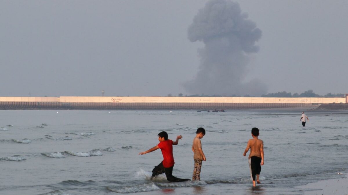 Three boys play in the waters of the Strait of Hormuz. The US and Iran each assert they control it after another heavy exchange of fire