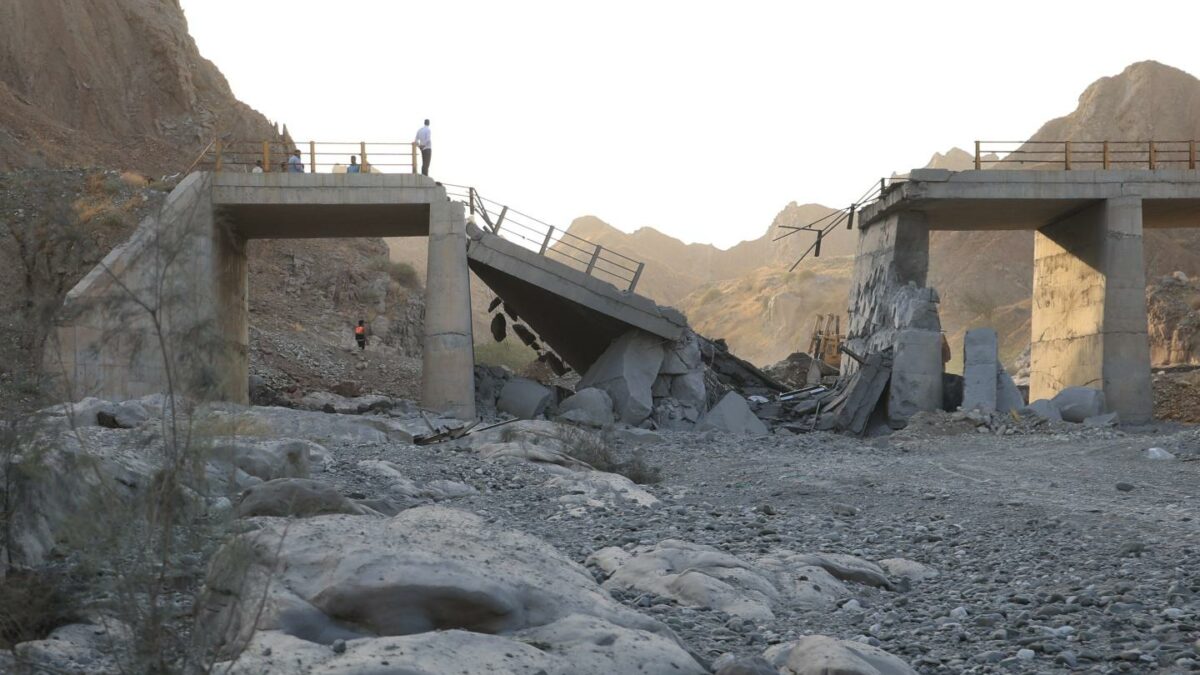People stand on a bridge destroyed after a strike in Hormozgan province, southern Iran, Saturday, July 18, 2026.