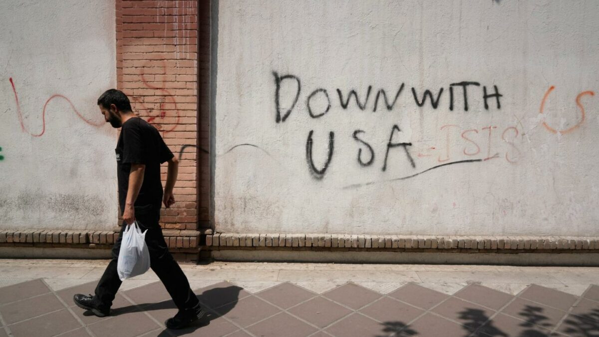 Photo of man walking past anti-U.S. graffit "Down with USA" in Tehran