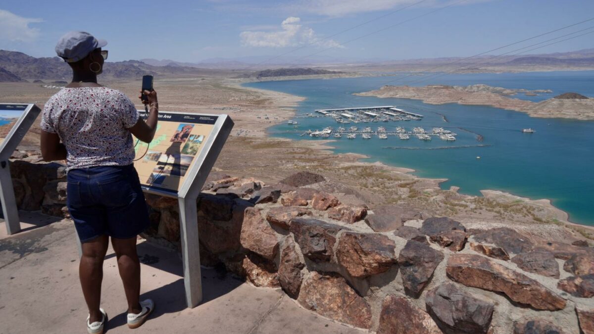A tourist takes a photo of Lake Mead near Boulder City, Nev., on Friday, Aug. 7, 2026.