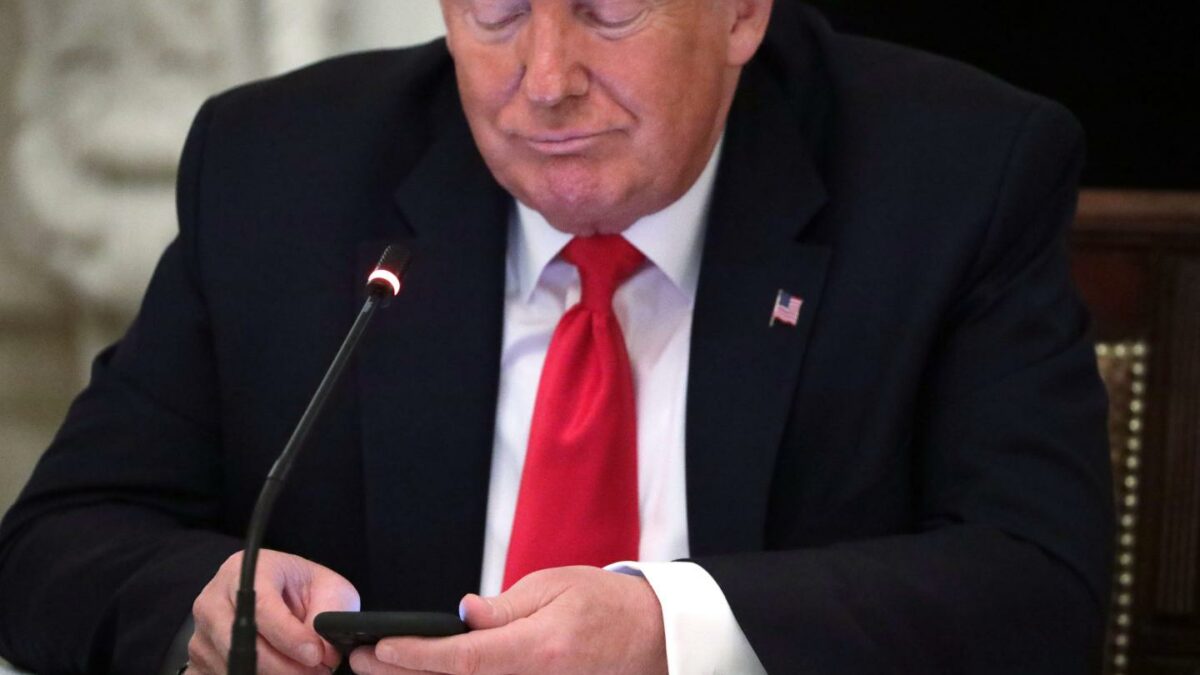 President Donald Trump looks at his phone during a roundtable at the State Dining Room of the White House June 18, 2020.