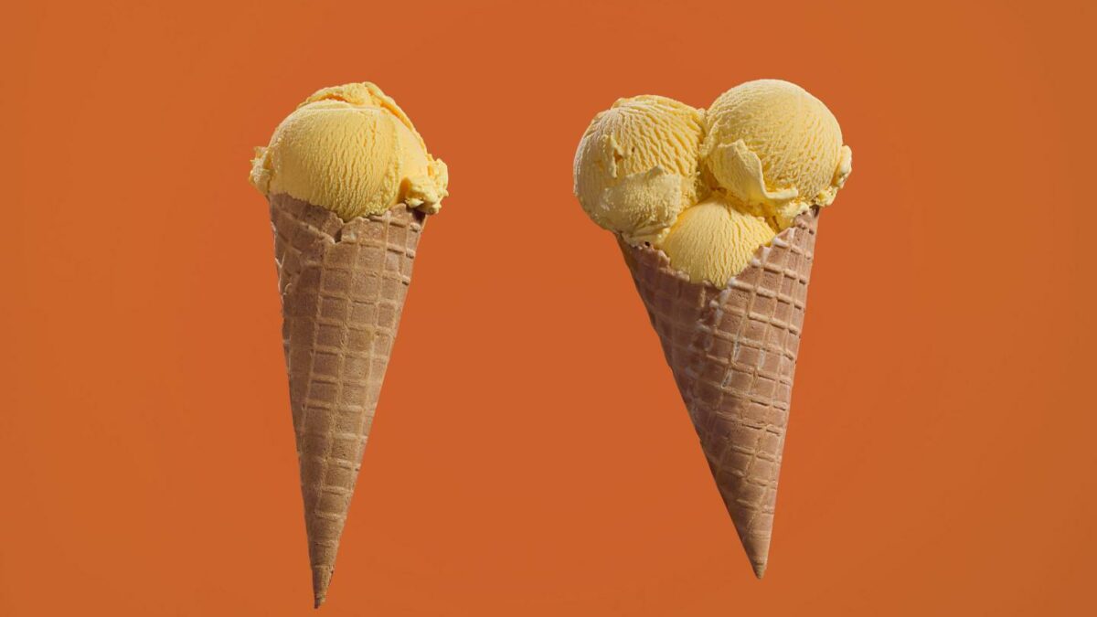 Two ice cream cones, one on the left with one scoop and one on the right with three scoops.
