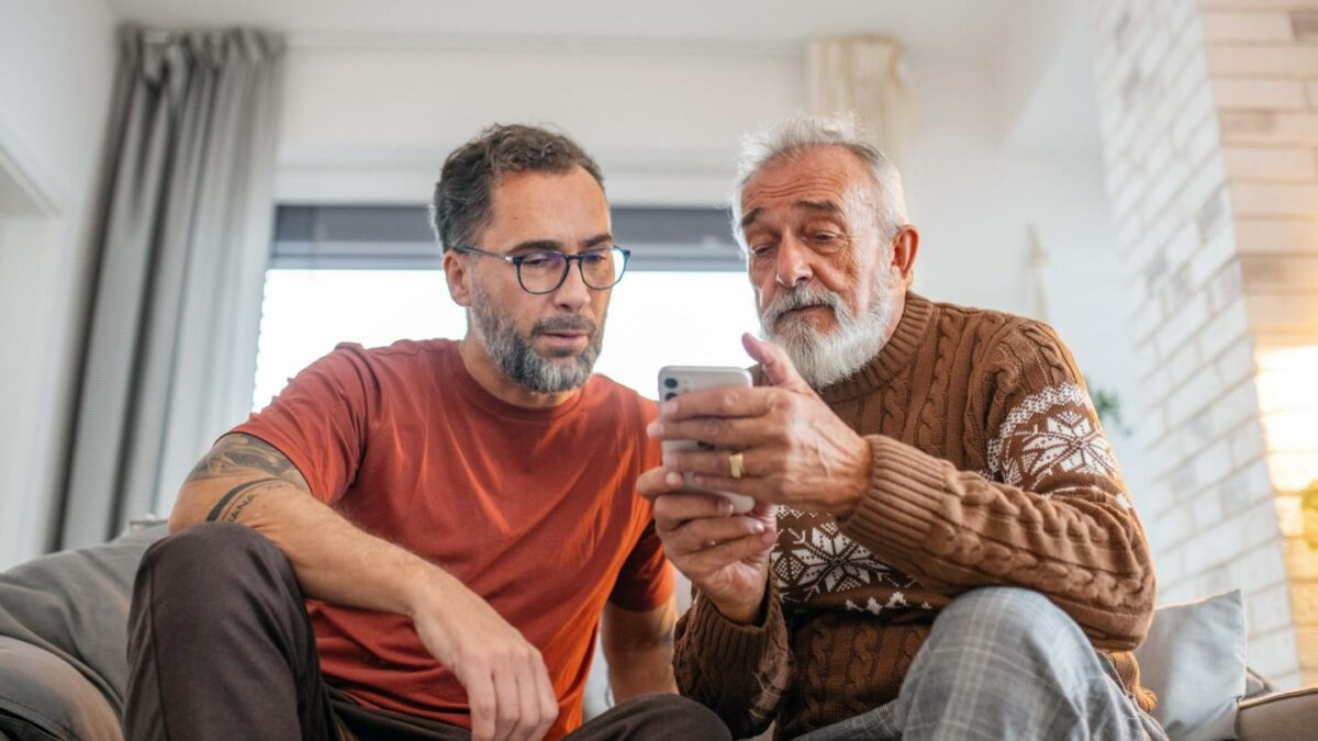 Son helping his dad do research on his phone