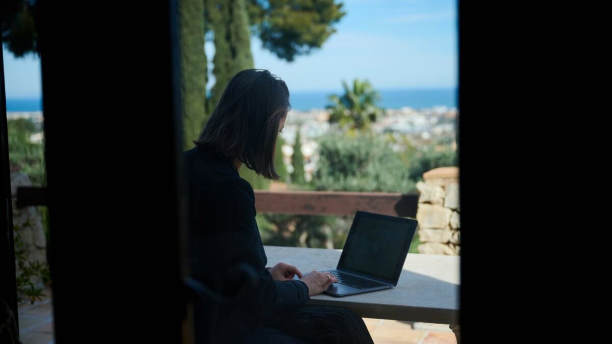 Photo of woman sitting at her laptop with a view of Spain