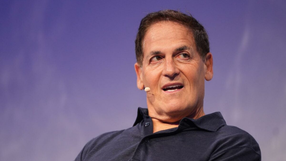Mark Cuban, in front of a purple background, has his mouth open and is looking to his left.