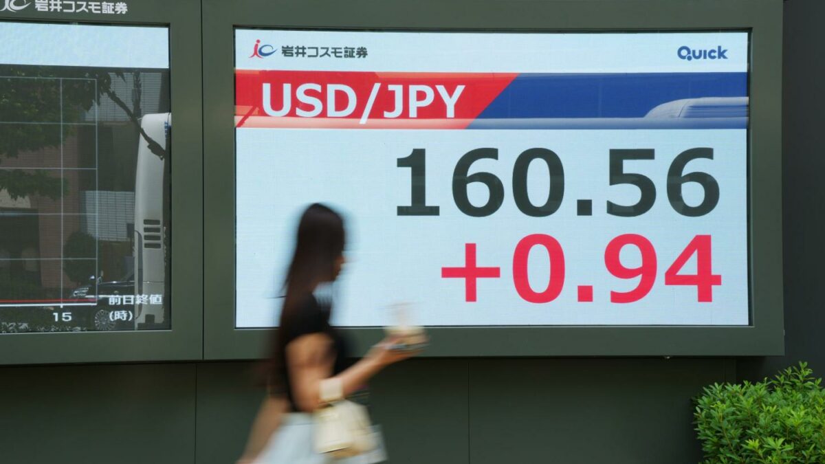 Photo of yen and dollar comparison and a woman walking past in a blur