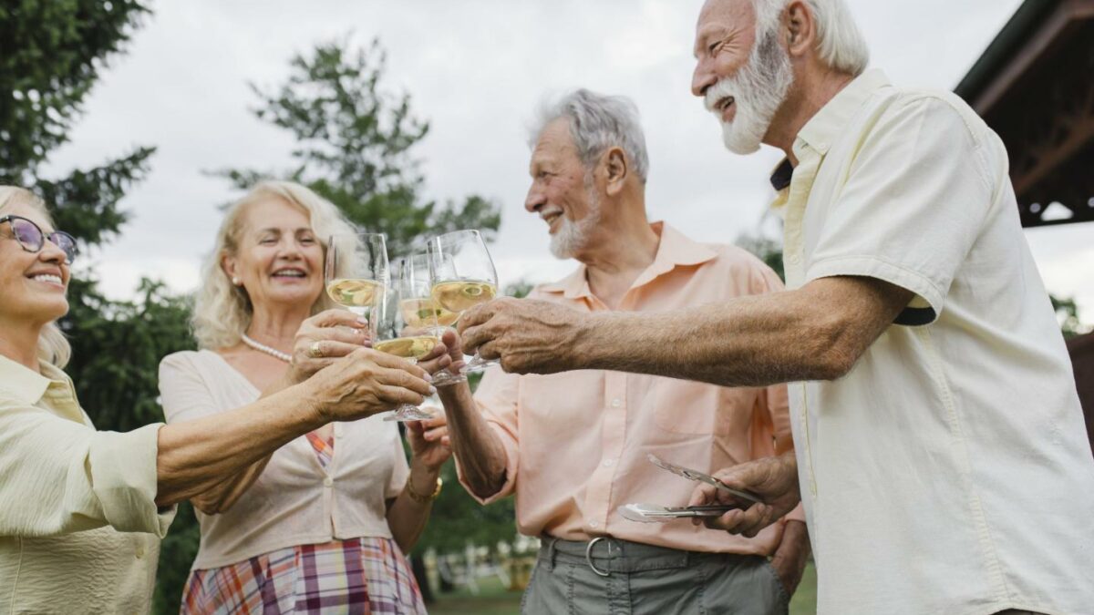 Two mature couples smiling and toasting one another
