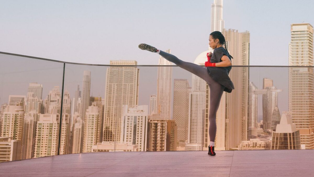 A woman on a rooftop practicing kickboxing.