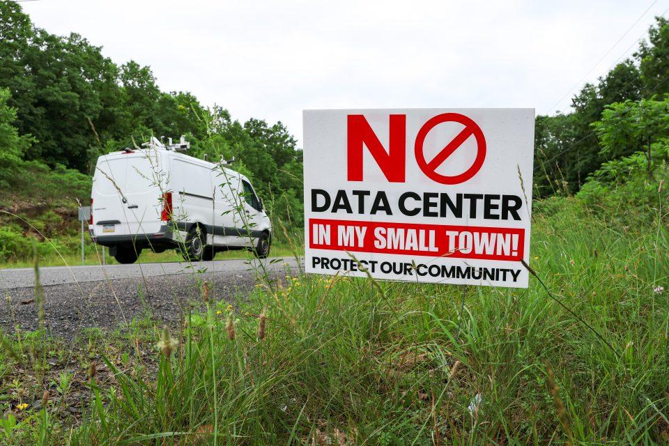 gettyimages-2282688345-e1790980109481 A "No data center in my backyard" sign stood in a patch of grass with a white van in the background.
